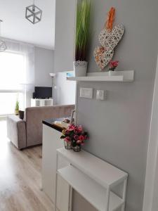a living room with a couch and a table with plants at Ukiel Park J&J in Olsztyn
