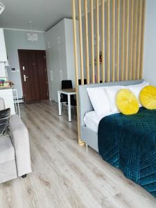 a bedroom with a bed with yellow pillows on it at Ukiel Park J&J in Olsztyn
