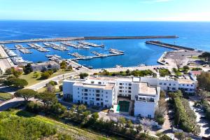 una vista aérea de un puerto deportivo con barcos en el agua en Le Residenze Blu Sardinia en La Caletta
