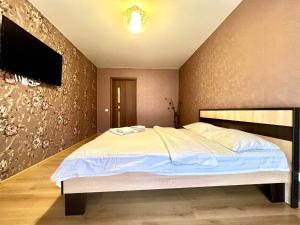 a bedroom with a large bed and a tv at ApartPoltava Затишна квартира в новобудові, панорамний балкон, банківський чек in Poltava