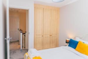 a bedroom with a white bed and a closet at Remarkable 4-Bed House in Cardiff in Cardiff