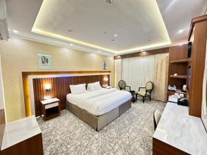a hotel room with a bed and a desk at فندق حياة تاون املج 1 in Umm Lajj