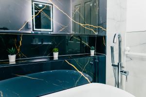 a bathroom with blue walls and a shower with plants at Remarkable 4-Bed House in Cardiff in Cardiff