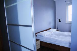 um pequeno quarto com uma cama e uma janela em Apartament Rodzinny em Bydgoszcz