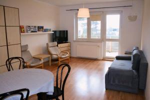 uma sala de estar com um sofá, uma mesa e cadeiras em Apartament Rodzinny em Bydgoszcz