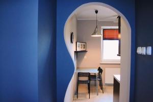 cocina con paredes azules, mesa y sillas en Apartament Rodzinny, en Bydgoszcz