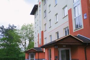 um edifício alto, vermelho e branco, ao lado de um edifício em Apartament Rodzinny em Bydgoszcz