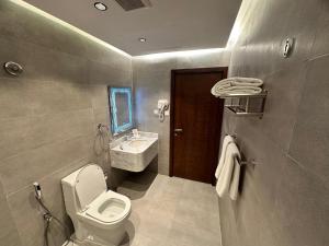 a bathroom with a toilet and a sink at فندق حياة تاون املج 1 in Umm Lajj
