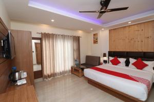 1 dormitorio con 1 cama grande y ventilador de techo en Hotel Elite Stay - Rajpur Road, en Dehradun