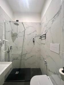 een badkamer met een douche, een toilet en een wastafel bij Hotel Sara in Milaan