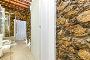 a stone bathroom with a toilet and a stone wall at Liù in Capoliveri