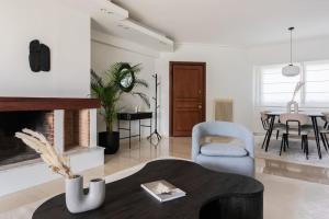 ein Wohnzimmer mit einem Kamin und einem Tisch in der Unterkunft Chic & Luminous 3BR Apartment in Kifisia by UPSTREET in Athen