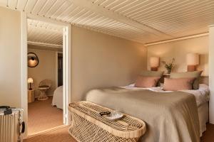 a bedroom with a large bed with pink pillows at Tisvildeleje Strandhotel in Tisvilde