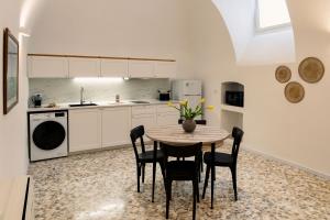 una cucina con un tavolo e sedie in una stanza di Auriga Luxury Flat a Modugno Altre 17 foto