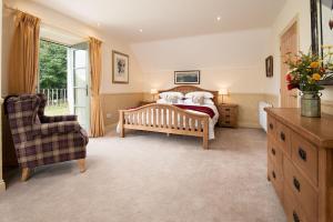 a bedroom with a bed and a couch and a chair at Dryburgh Steading Four in Saint Boswells