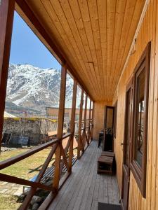a wooden porch with a view of a snow covered mountain at Family Hostel Nika in Kazbegi