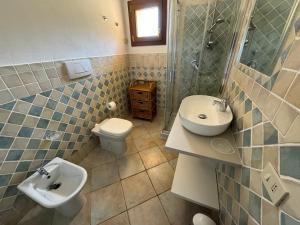 a bathroom with two sinks and a toilet at Appartamento il Caracolo a Cala Francese in La Maddalena