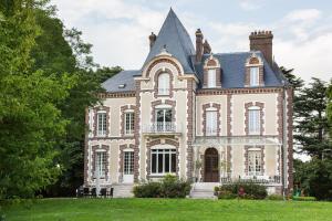 una casa vieja con una torreta en el césped en Château de la Folie, en Trie-Château