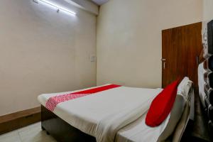 a small bedroom with a bed with red pillows at OYO HOTEL MANNAT in Alīgarh