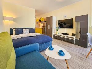 1 dormitorio con 1 cama azul y sala de estar en visit baltic - Monte Cassino, en Świnoujście
