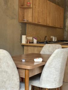 drewniany stół i 2 krzesła oraz kuchnia w obiekcie Family Hostel Nika w mieście Stepancminda