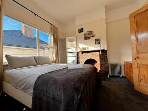 a bedroom with a large bed and a fireplace at Enchanting Vintage House at South Hobart in Hobart