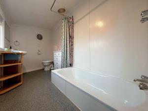 a white bathroom with a tub and a toilet at Enchanting Vintage House at South Hobart in Hobart +16 photos