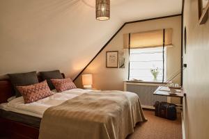 een slaapkamer met een groot bed en een raam bij Tisvildeleje Strandhotel in Tisvilde