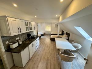 a kitchen with white cabinets and a living room at Durmaz Hotel in Hannover
