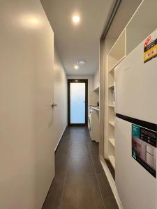 a hallway leading to a kitchen with a refrigerator at 3 bedroom Apartment at Kingston in Kingston +13 photos