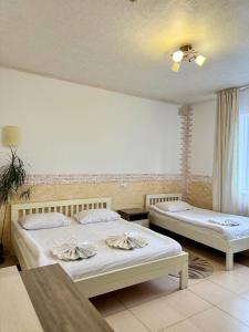 a bedroom with two beds and a ceiling fan at Trio Hotel Restaurant in Ivano-Frankivsk