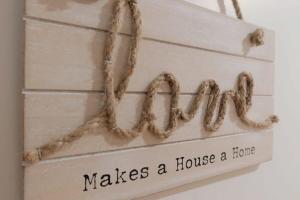 a sign that says makes a house a home at Seaside Chic Villa with Breathtaking Ocean Views in Howrah