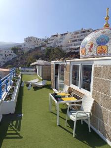 un balcón con mesa y sillas y un edificio en Apartamento Atlantico en Santa Cruz de Tenerife