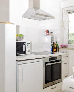 cocina blanca con microondas y fogones en WAREHOUSE 33, en Zagreb