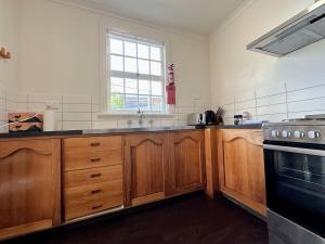 a large kitchen with wooden cabinets and a window at Hobart City Oasis with 3 beds in Hobart