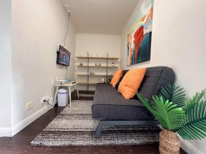 a living room with a couch and a plant at Hobart City Oasis with 3 beds in Hobart