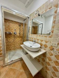 a bathroom with a sink and a shower at Appartamento il Paguro a Cala Francese in La Maddalena