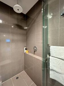 a bathroom with a shower with a glass door at City Retreat for 8 with Spacious Rooms in Hobart