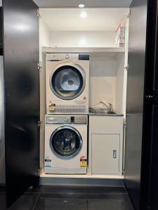 uma máquina de lavar e secar roupa num pequeno quarto em City Retreat for 8 with Spacious Rooms em Hobart