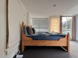 a bedroom with a wooden bed with a window at Econo Lodge near Hobart City and Salamanca Market in Hobart