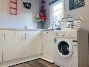 a laundry room with a washing machine and a window at Fonton Blue Holiday Home close to City and Airport in Moonah