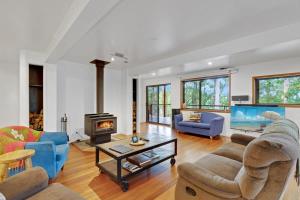 a living room filled with furniture and a fireplace at Hastings Bay Retreat in Hastings