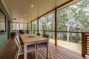 a screened in porch with a wooden table and chairs at Hastings Bay Retreat in Hastings