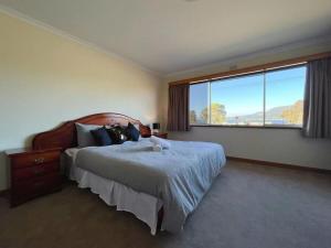 a bedroom with a large bed and a large window at Rose Retreat with Water Front view at Montrose in Rosetta