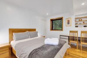 1 dormitorio con 1 cama con mesa y escritorio en Hastings Bay Retreat, en Hastings