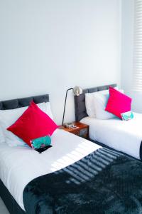dwa łóżka siedzące obok siebie z czerwonymi poduszkami w obiekcie Stunning-Gated-Listed Stay-Park-Homestay-Retreat w Londynie