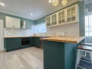 a kitchen with green cabinets and a counter top at SandyBay Garden Hideaway in Sandy Bay