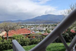 a view of a town with mountains in the background at Skyline Serenity Lower - Close to city and airport in Lindisfarne +1 photo