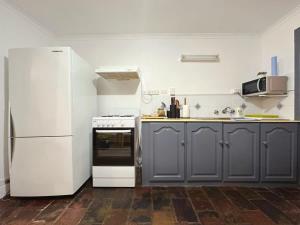 a kitchen with a white refrigerator and a stove at Wellesley Mountain View Getaway near City in Hobart