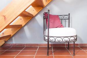 a black chair with a red pillow sitting under a staircase at House in Rodalquilar valley in Rodalquilar